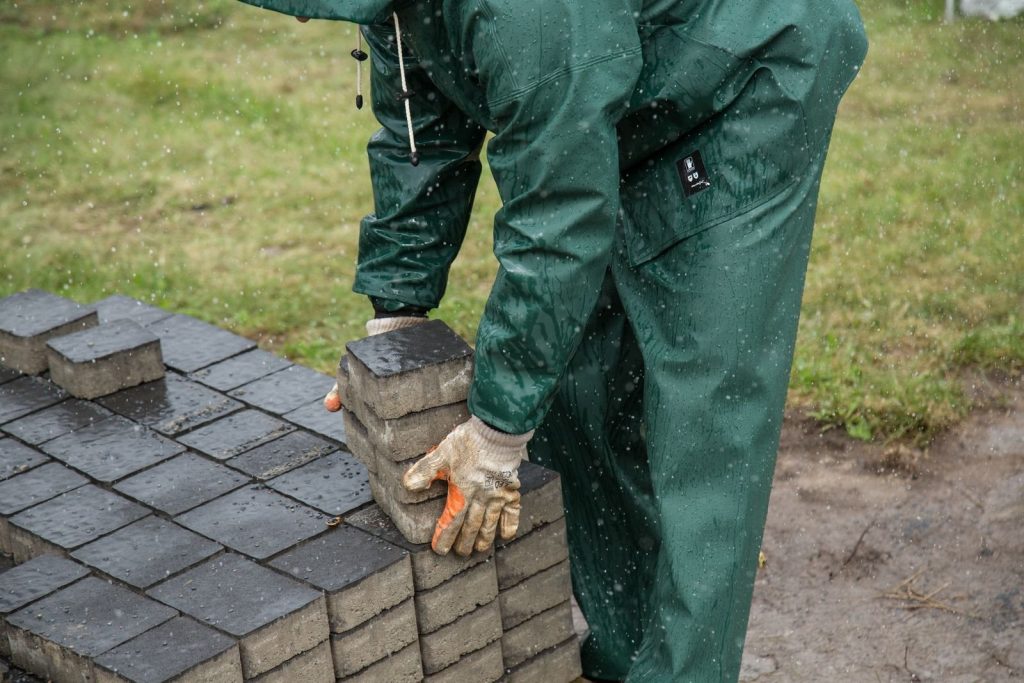 Pracownik układa elementy nawierzchni podczas prac zewnętrznych